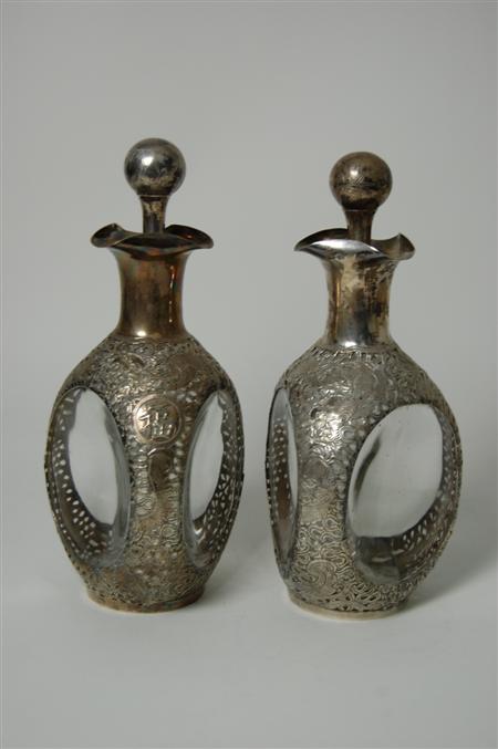 Appraisal: A pair of eastern silver mounted Dimple whisky bottles unmarked