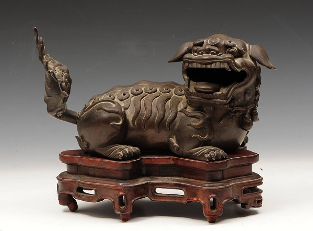 Appraisal: A CHINESE BRONZE KYLIN with head turned to side and