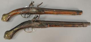 Appraisal: Two flintlock pistols with inset brass plaques and carved wood