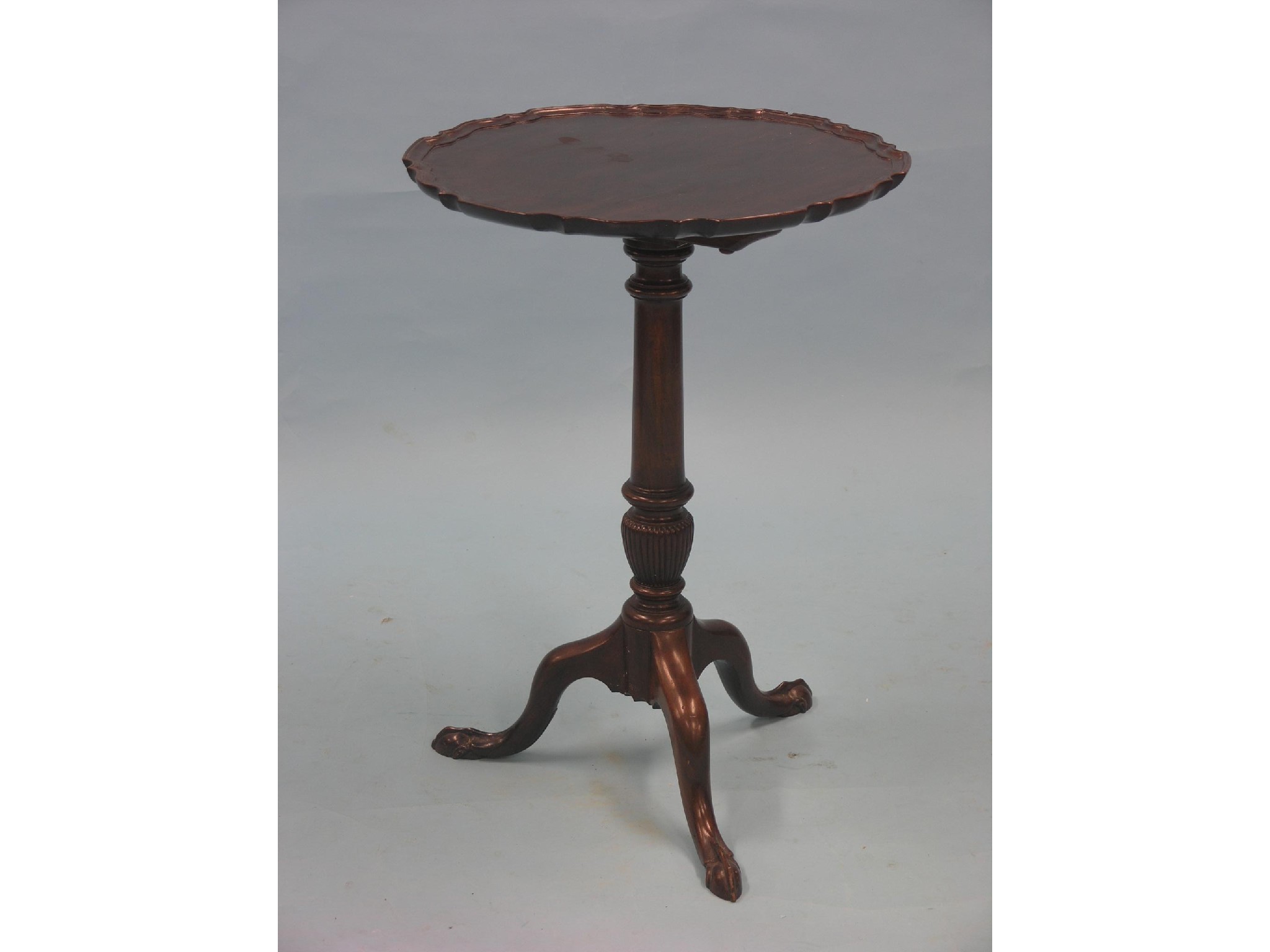 Appraisal: A Chippendale-style mahogany tilt-top tripod table circular pie-crust top tilting