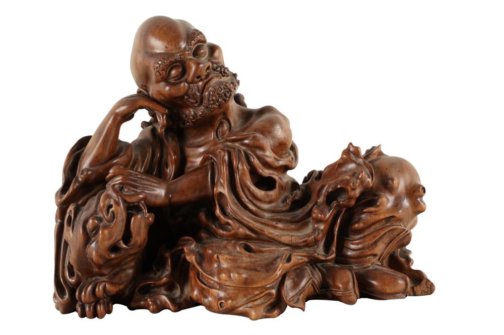 Appraisal: CHINESE CARVED WOOD FIGURAL GROUPdepicting a man resting on foo