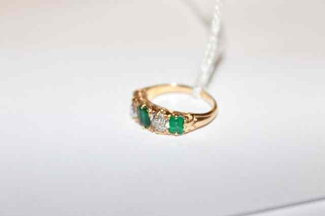 Appraisal: AN CT GOLD RING SET WITH CENTRAL EMERALD flanked by