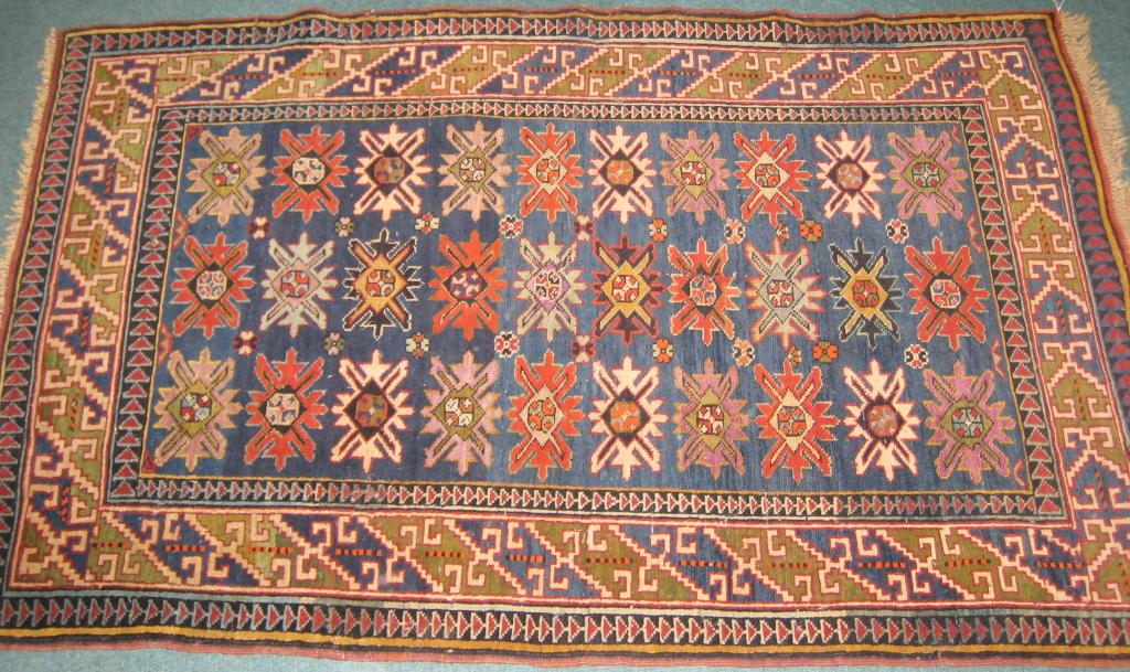 Appraisal: A bordered Kazak Rug with stylised rosettes in red camel