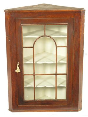 Appraisal: A th century mahogany hanging corner cupboard the glazed door