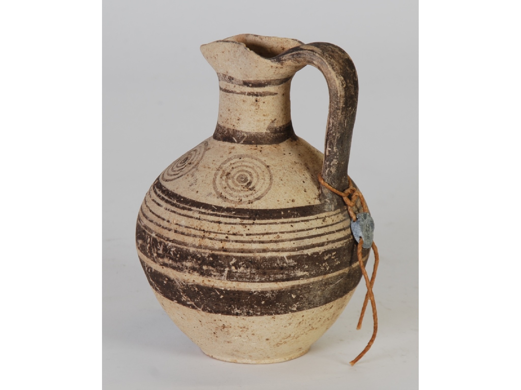 Appraisal: AN ANCIENT TERRACOTTA GLOBULAR JUG with loop handle and brown