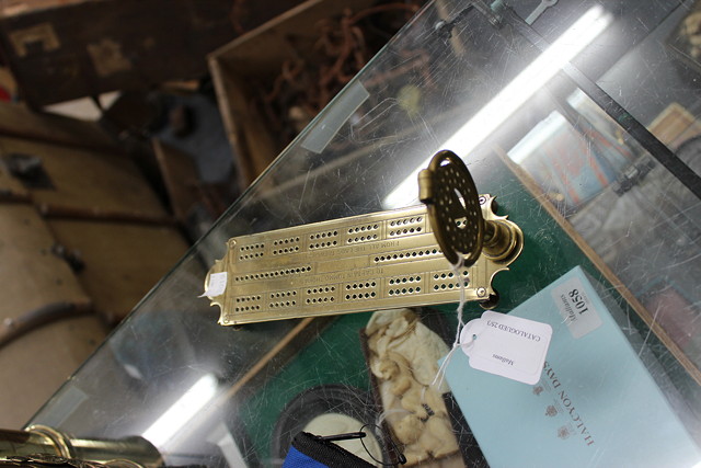 Appraisal: A BRASS CRIBBAGE BOARD mounted at one end with a