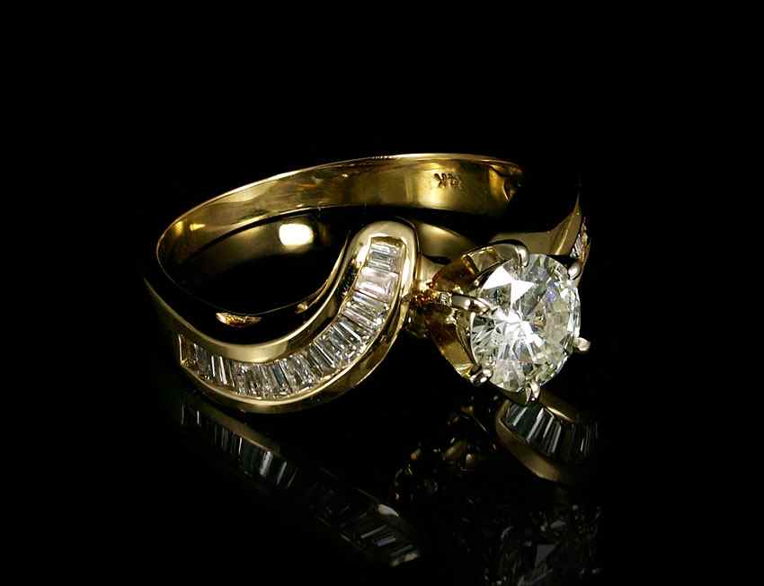 Appraisal: CT DIAMOND SOLITAIRE WITH BAGUETTES K yellow gold ring contains