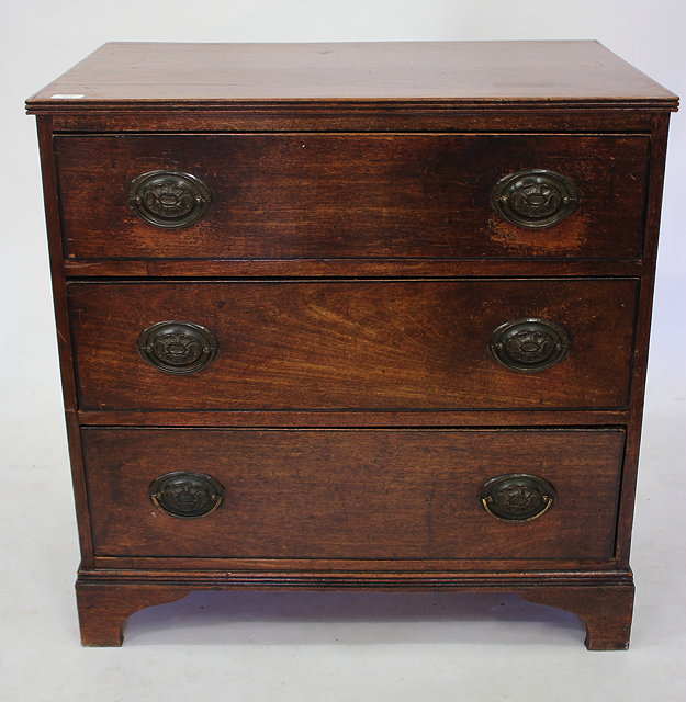 Appraisal: AN ANTIQUE MAHOGANY CHEST of three long drawers with oval