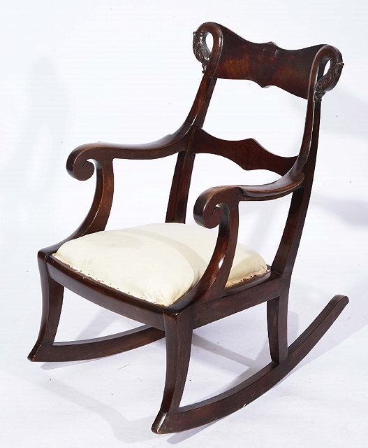 Appraisal: A MAHOGANY ROCKING CHAIR with carved dolphin variation and broad