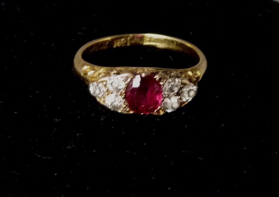 Appraisal: A ruby and diamond ring the central ruby flanked by