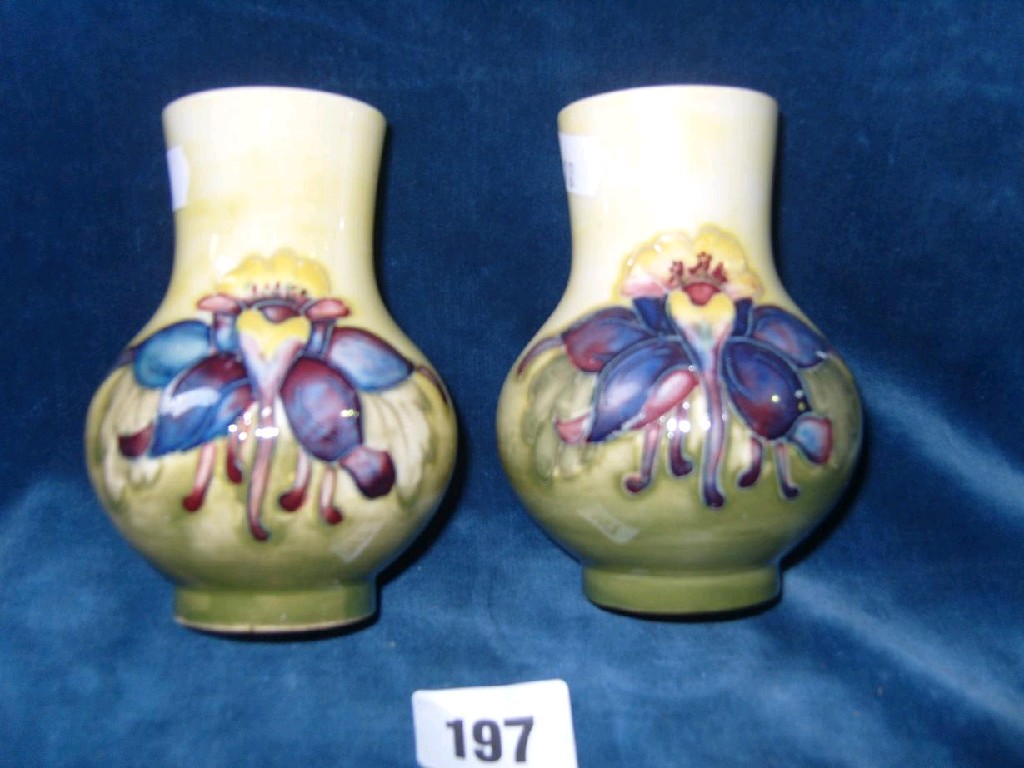 Appraisal: A pair of Moorcroft vases with bulbous bodies and cylindrical