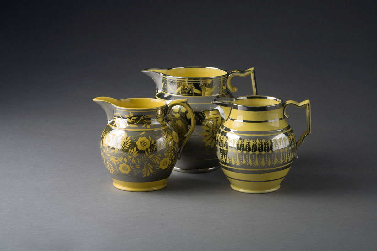 Appraisal: THREE ENGLISH YELLOW-GLAZED SILVER RESIST JUGS CIRCA - Resisted in