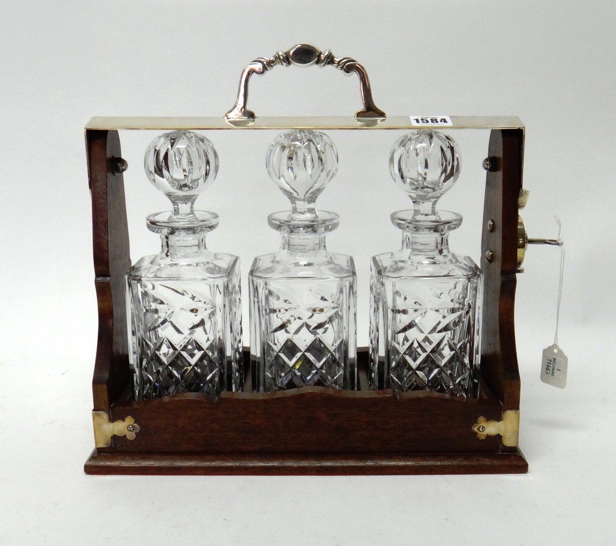 Appraisal: A silver plated metal mounted mahogany tantalus fitted with three