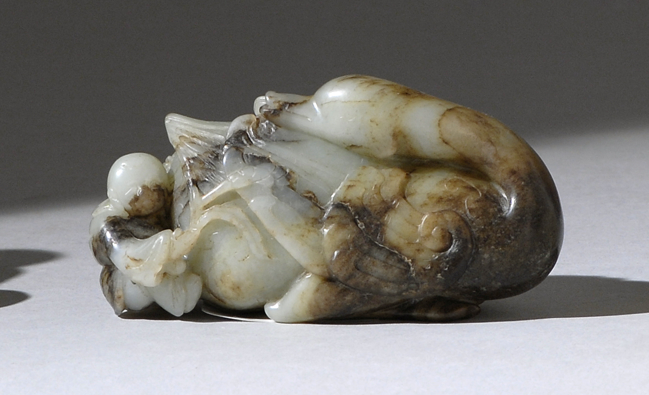 Appraisal: CELADON AND BROWN JADE CARVING th th CenturyIn the form