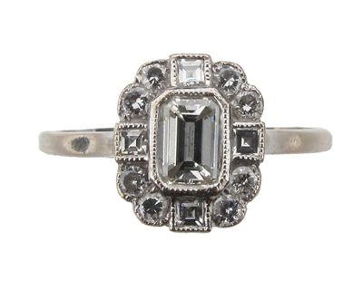 Appraisal: A diamond cluster ring The emerald cut diamond is set