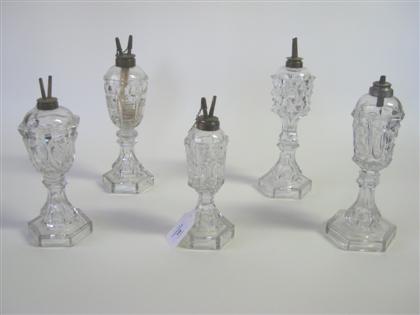 Appraisal: Five uncolored pressed glass fluid lamps new england Various patterns