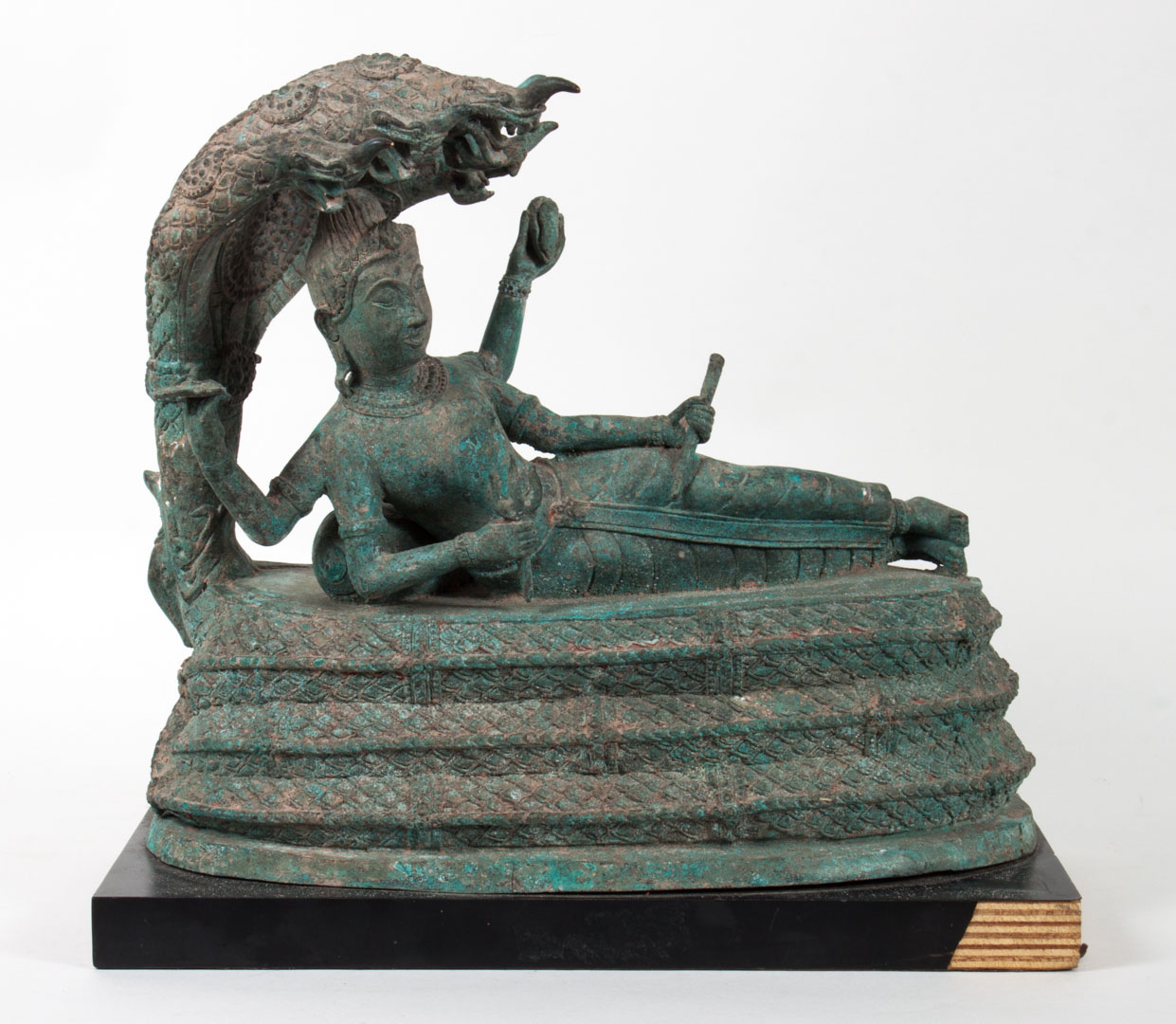 Appraisal: Indian bronze figure of Naga reclining multi-armed deity being shaded