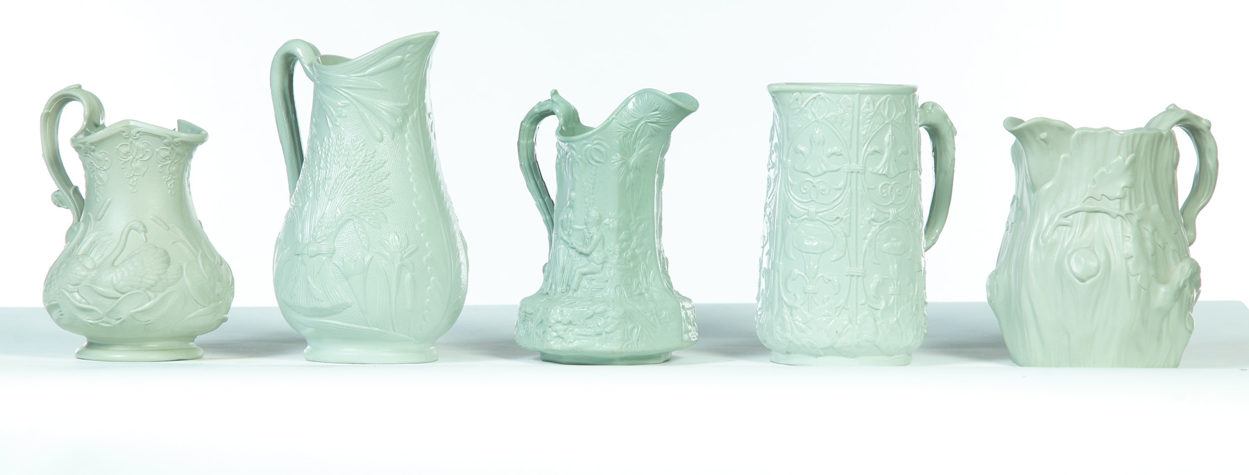 Appraisal: FIVE RELIEF MOLDED GREEN PITCHERS England mid th century Various