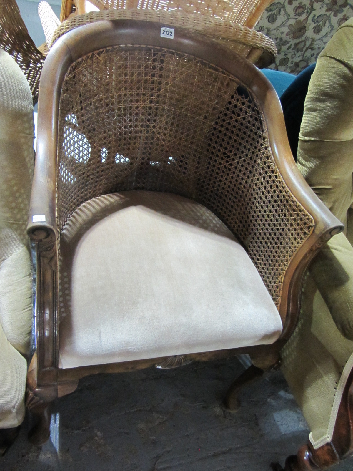 Appraisal: A th century walnut tub chair with cane back and