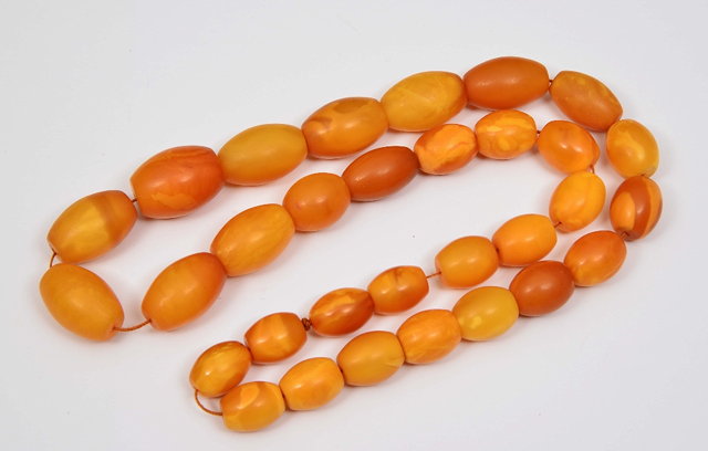 Appraisal: A STRING OF GRADUATED AMBER BEADS approximately cm long grams