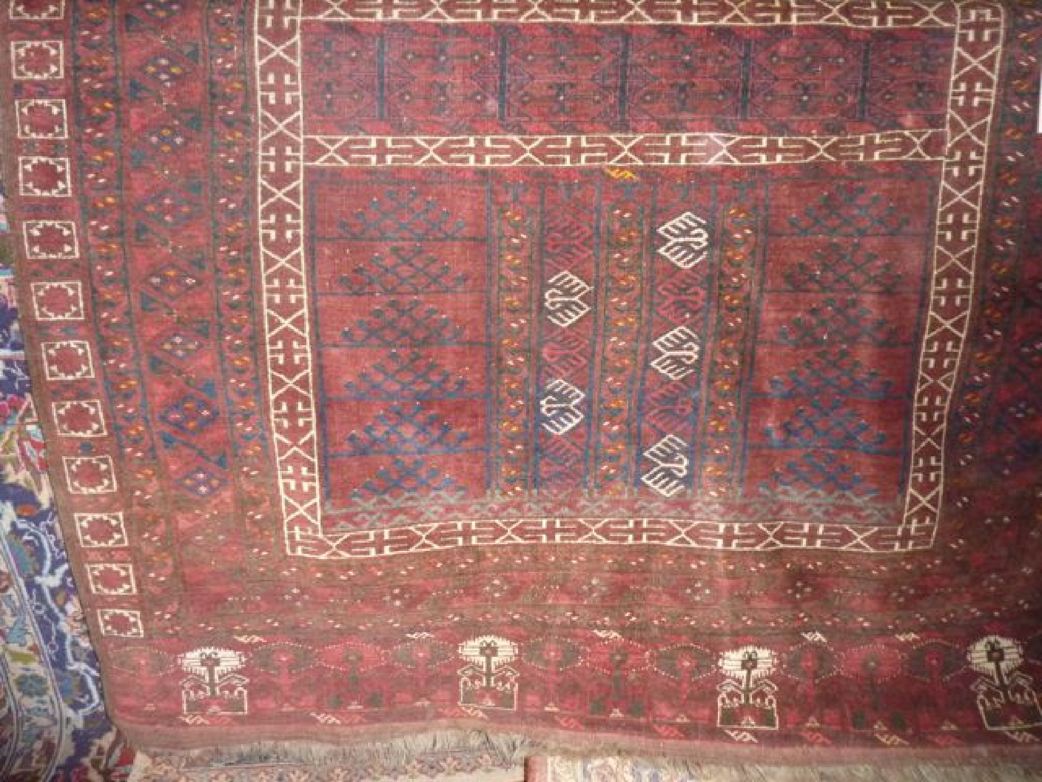 Appraisal: An Afghan red wool carpet with geometric detail x cm