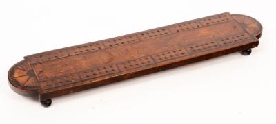 Appraisal: A fruitwood cribbage board the rounded ends inlaid batwing patera