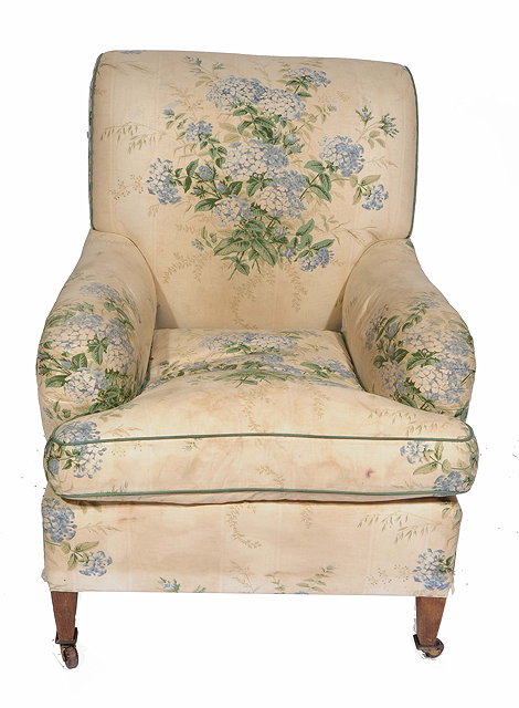 Appraisal: A FLORALLY UPHOLSTERED HOWARD STYLE ARMCHAIR standing on square section