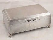 Appraisal: A silver cigarette box on pad feet engine turned with