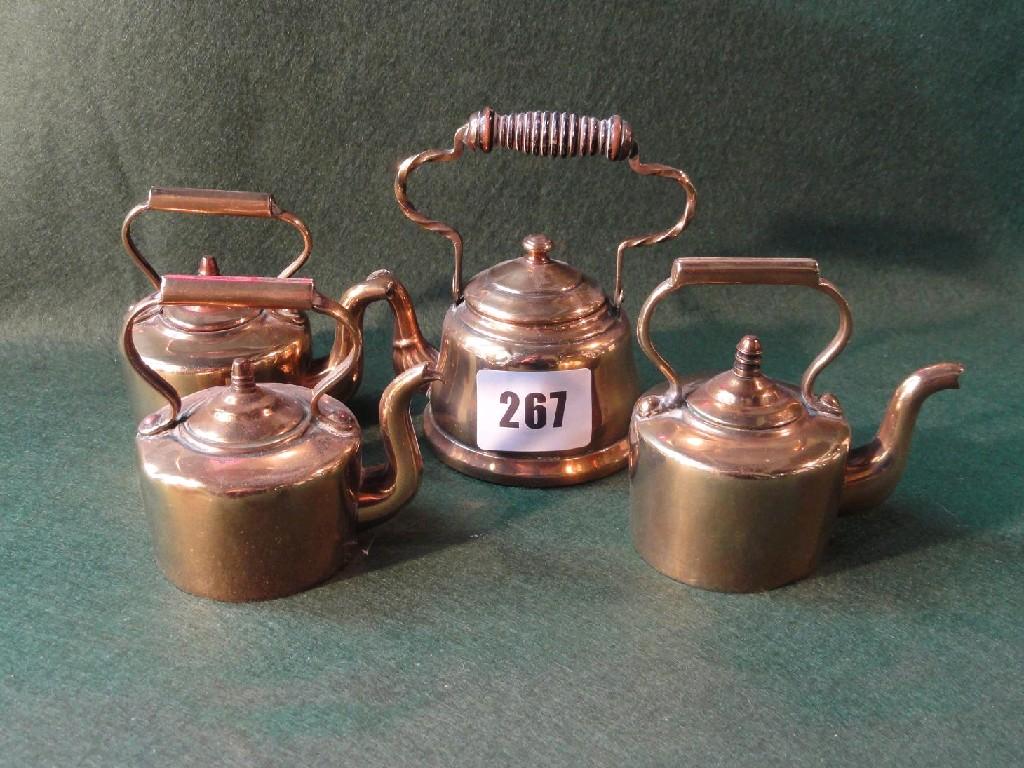 Appraisal: A collection of four miniature brass kettles with shaped looped