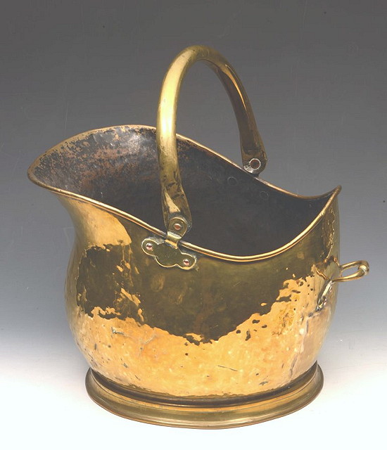 Appraisal: A VICTORIAN HELMET SHAPED COAL SCUTTLE with swing handle