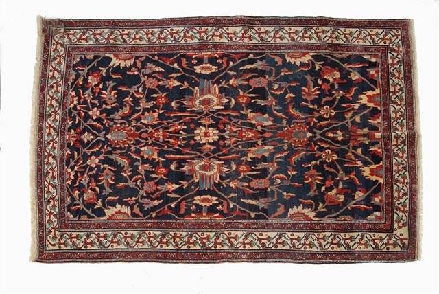 Appraisal: A PERSIAN BLUE GROUND RUG decorated a central spray of