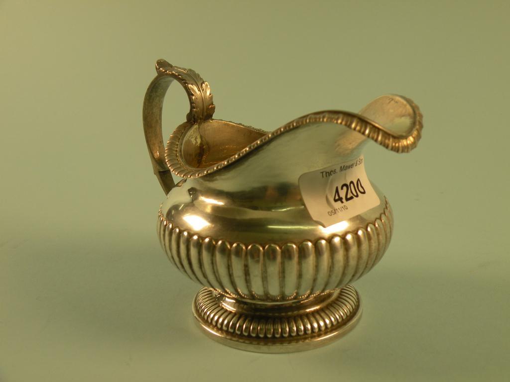 Appraisal: A George IV silver part fluted milk jug with acanthus