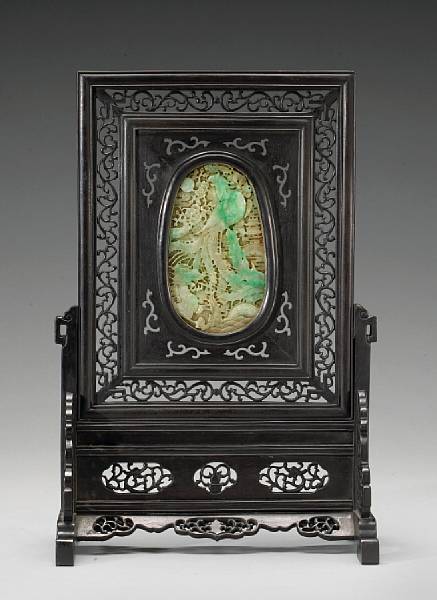 Appraisal: An oval jadeite plaque mounted in a hardwood table screen