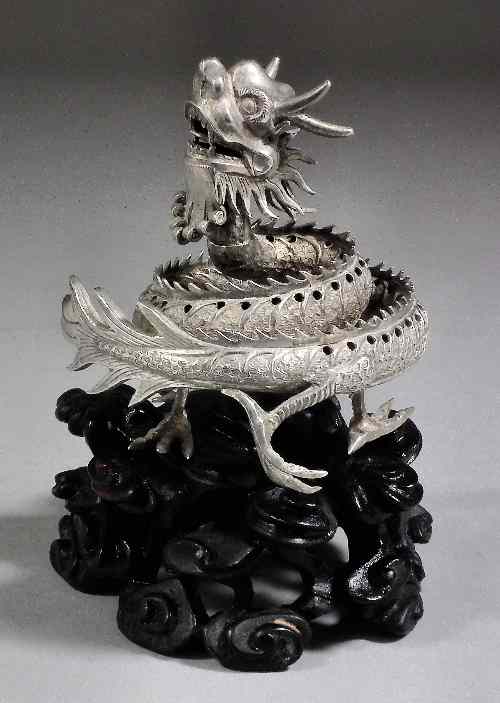 Appraisal: A Chinese silvery metal figure of a coiled dragon on