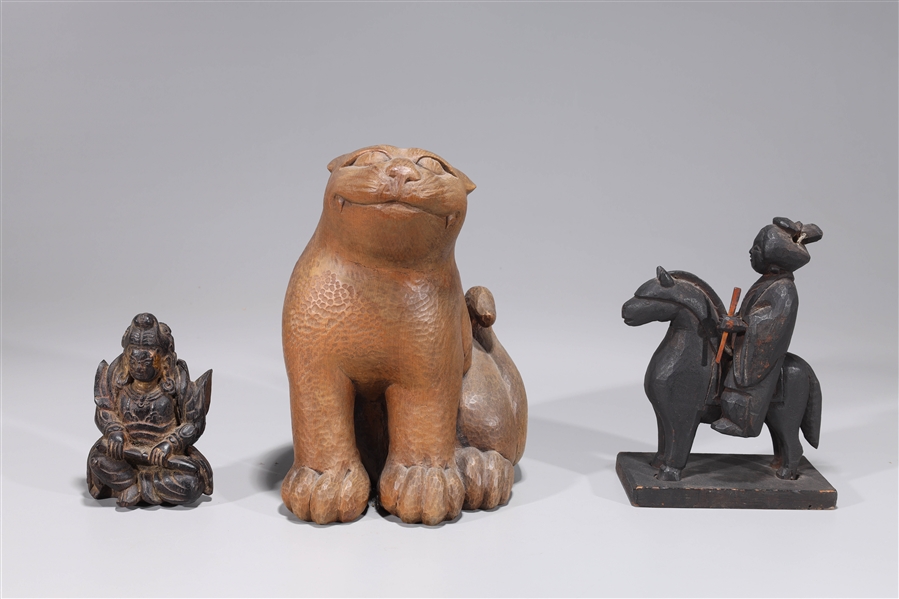 Appraisal: Group of three Japanese wood carvings including seated feline with