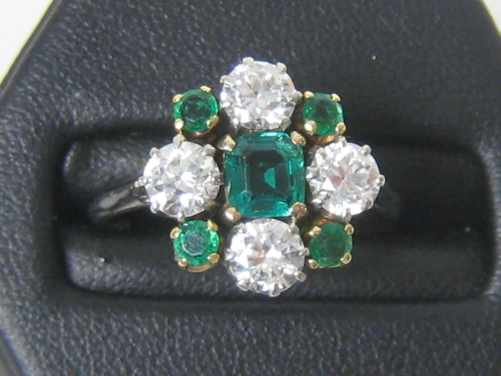 Appraisal: An Emerald and Diamond Cluster Ring claw-set central square-cut emerald