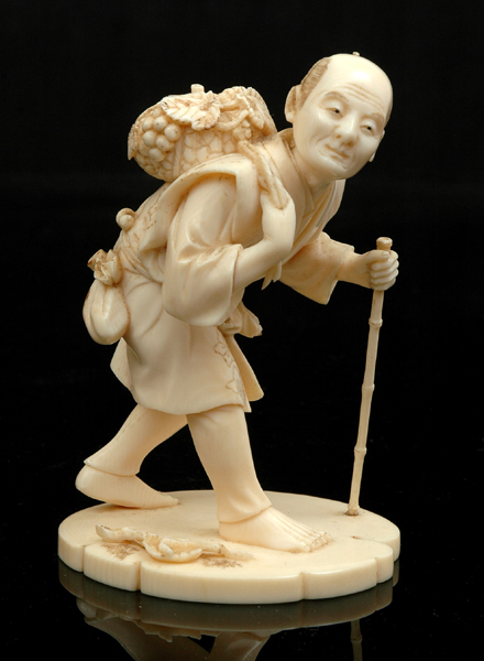 Appraisal: A JAPANESE CARVED IVORY OKIMONO OF A GRAPESELLER Meiji Period