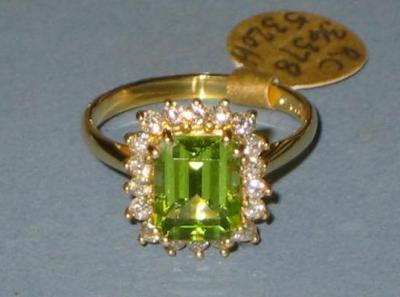 Appraisal: A PERIDOT AND DIAMOND CLUSTER RING the emerald-cut peridot set