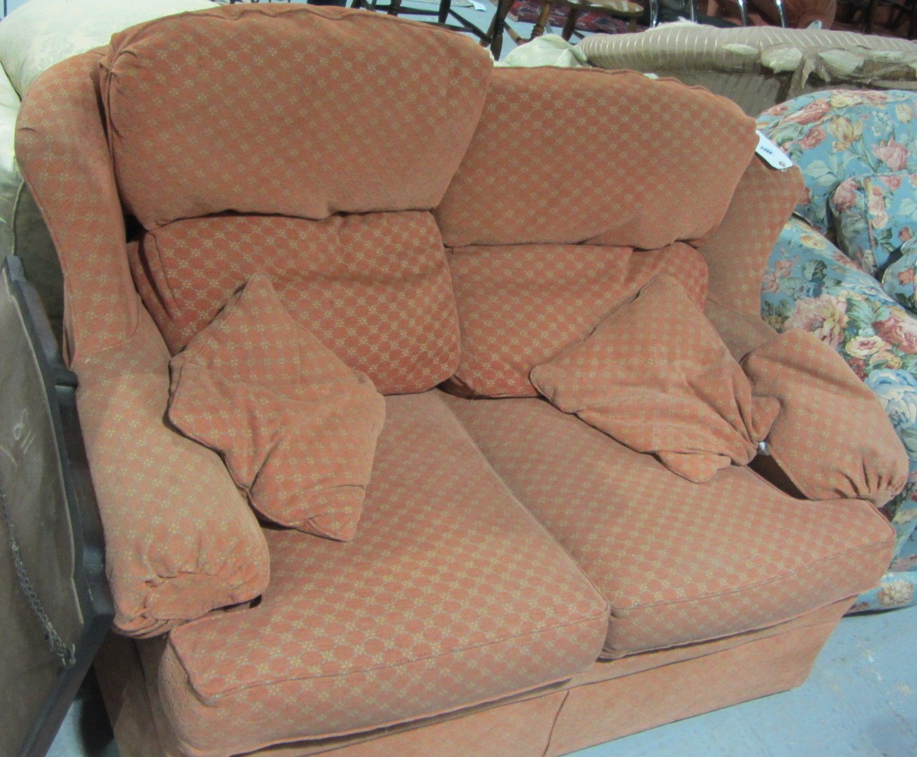 Appraisal: A two seater sofa with burnt orange upholstery with a