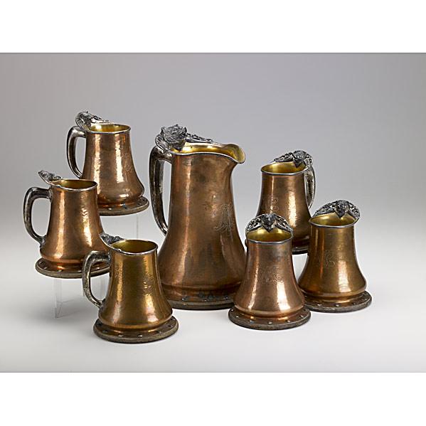 Appraisal: JOSEPH HEINRICHSHammered copper brass silver and oak tankard set with