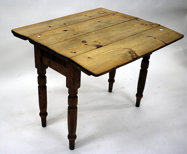 Appraisal: A PINE DROP LEAF DINING TABLE on turned tapering legs