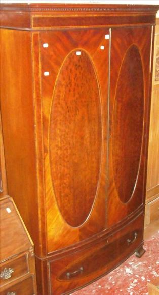 Appraisal: An Edwardian figured and crossbanded mahogany bowfront wardrobe fitted with