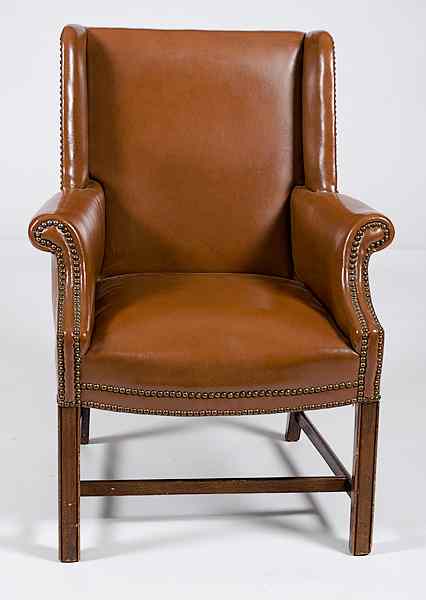 Appraisal: Leather Chair th century a brown leather wing chair having