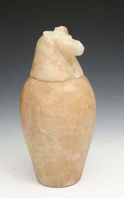 Appraisal: AN EGYPTIAN CANOPIC ALABASTER VASE AND JACKALL MASK COVER of