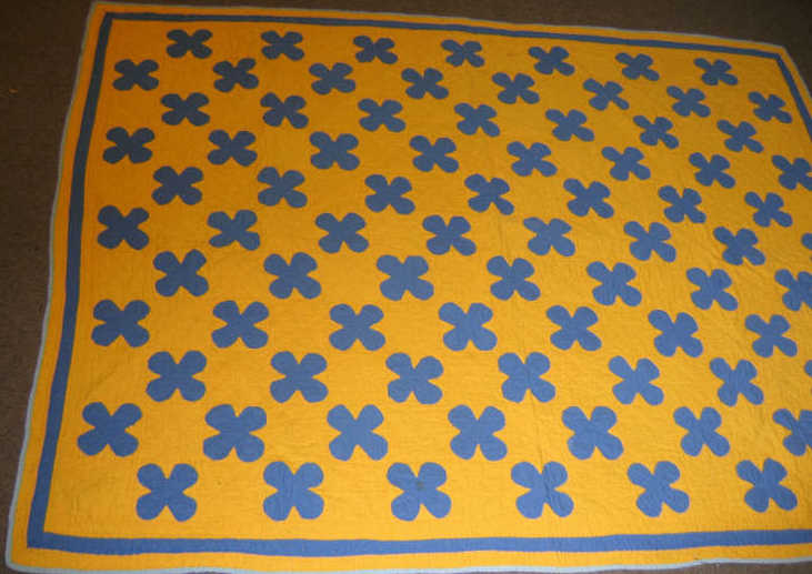 Appraisal: APPLIQUE FLOWERHEAD CHILD'S QUILT Blue on yellow ground formed by