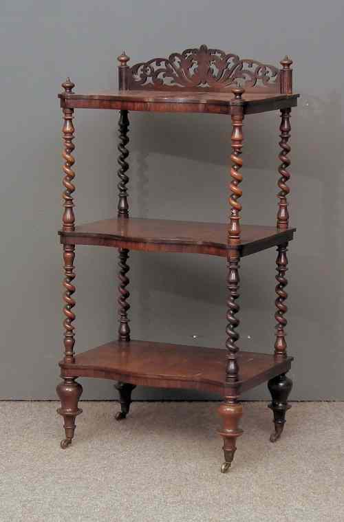 Appraisal: A Victorian rosewood serpentine fronted three tier whatnot with pierced