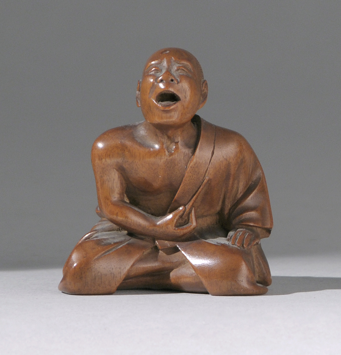 Appraisal: WOOD NETSUKE th CenturyDepicting a sneezer in seated position Signed