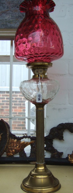 Appraisal: A brass oil lamp with cranberry glass shade th century