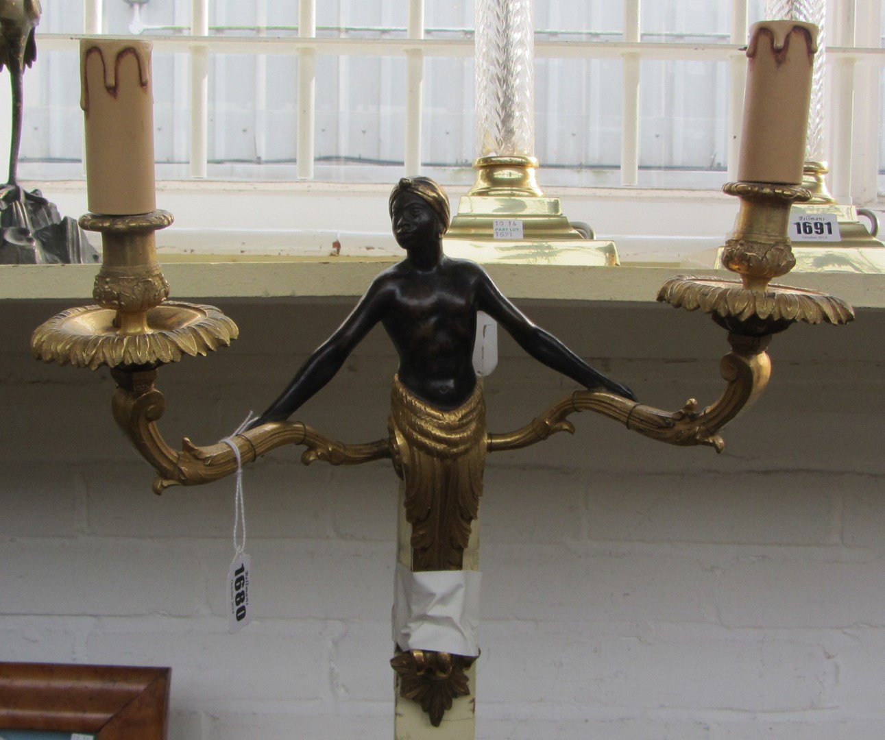 Appraisal: A pair of patinated and gilt bronze twin light wall