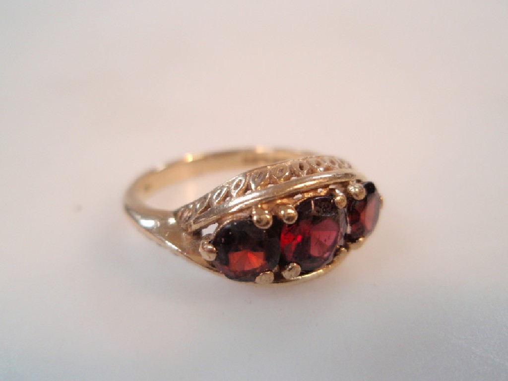 Appraisal: A ct gold marquise ring set with three red stones